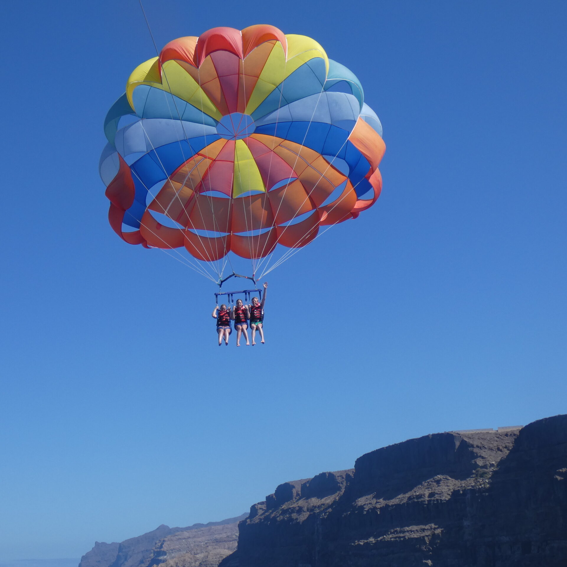alt="Three guests parasailing during an Afrikat boat trip in Gran Canaria"